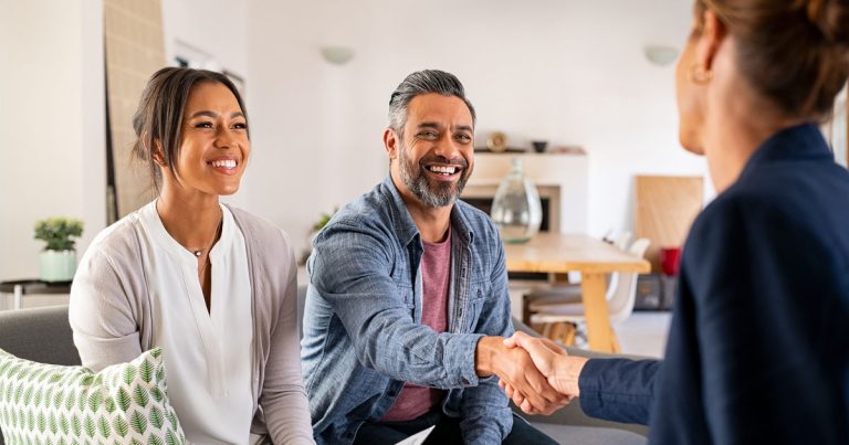 smiling man shaking woman's hand